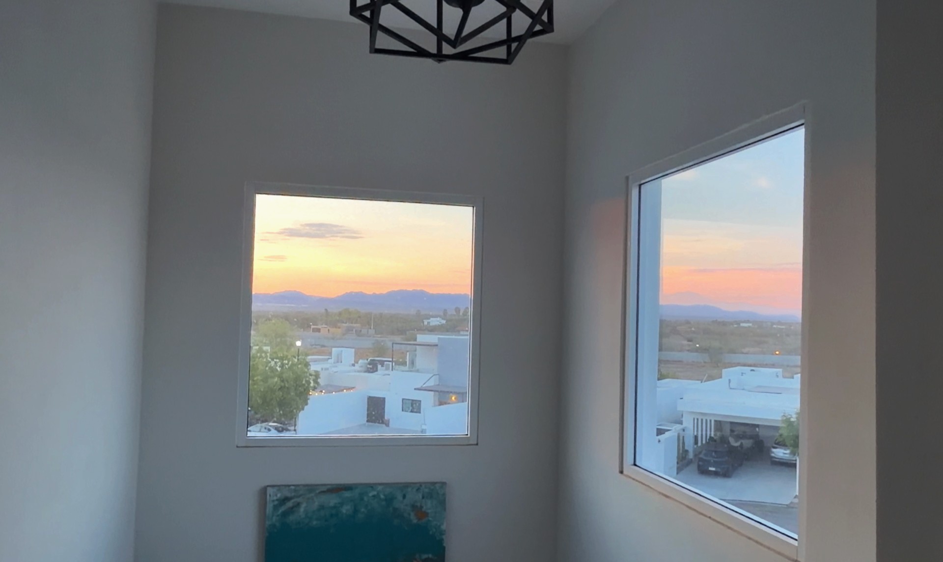 Upper landing framed by tall windows and a dusk sky